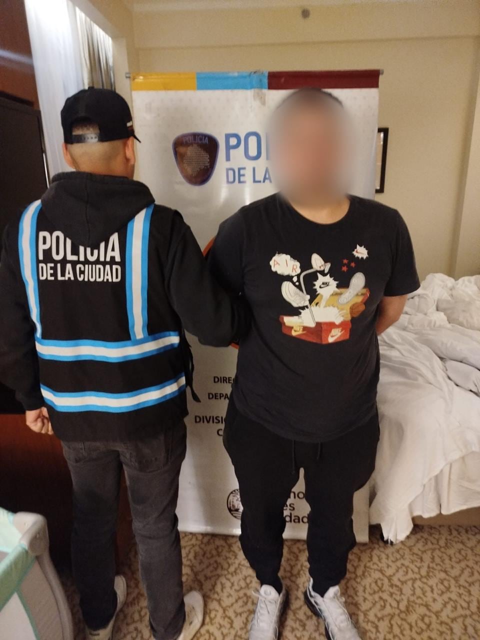 Un agente de la Policía de la Ciudad junto a uno de los detenidos