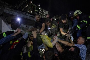 Rescatistas y voluntarios transportan a una mujer rescatada de entre los escombros en el lugar donde se encuentran edificios de hoteles y restaurantes fuertemente dañados por un ataque con misiles rusos, en medio del ataque de Rusia a Ucrania, en el centro de Kramatorsk, región de Donetsk, Ucrania 27 de junio de 2023. REUTERS/Oleksandr Ratushniak