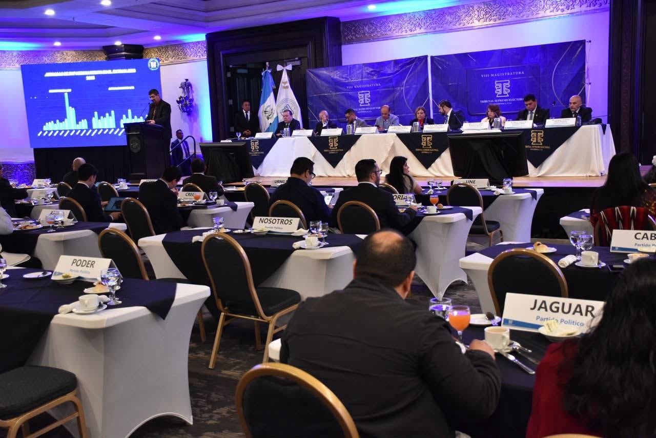 El Tribunal Supremo Electoral de Guatemala encabeza una sesión de trabajo con delegados de diversos partidos políticos en un salón de actos. (TSE Guatemala)