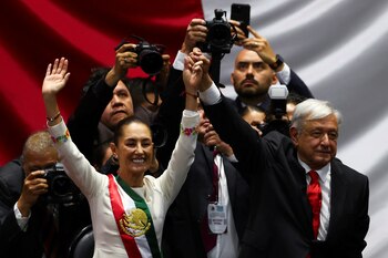 Mexico's new President Claudia Sheinbaum raises hands with outgoing President Andres Manuel Lopez Obrador during her swearing-in ceremony at Congress, in Mexico City, Mexico, October 1, 2024. REUTERS/Raquel Cunha