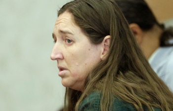 Vista lateral de Megan Huntsman, una mujer de cabello castaño largo, con expresión seria, en un entorno interior con luz suave