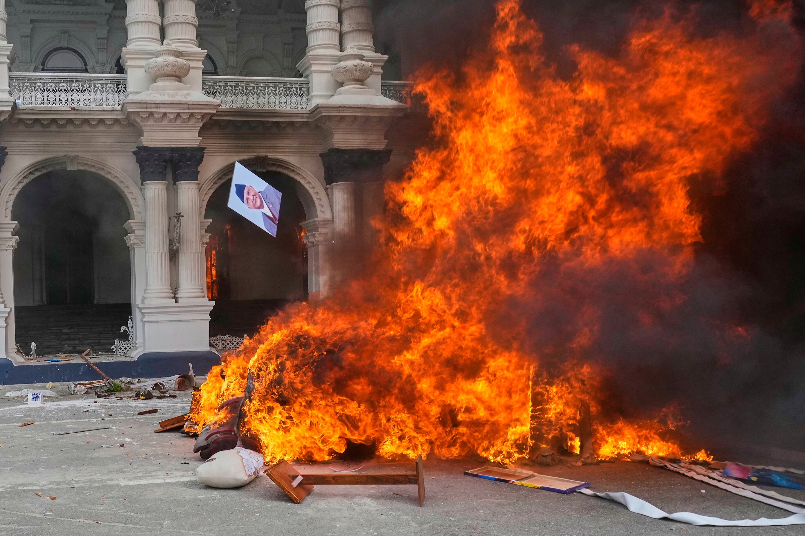 A protester throws a photograph of Nepal Prime Minister Khadga Prasad Oli in the fire at the Singha Durbar, the seat of Nepal
