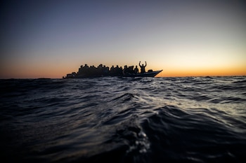 Migrantes y refugiados esperan ayuda a bordo de una embarcación de madera sobrecargada en el mar Mediterráneo (AP Foto/Bruno Thevenin, archivo)