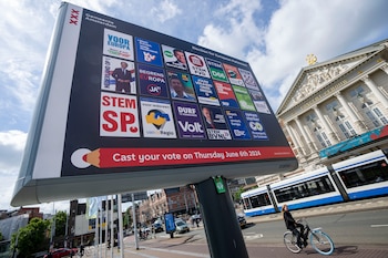 Una ciclista pasa junto a un cartel de las elecciones europeas ante la sala de conciertos Concertgebouw en Ámsterdam, Holanda, el miércoles 5 de junio de 2024. (AP Foto/Peter Dejong)