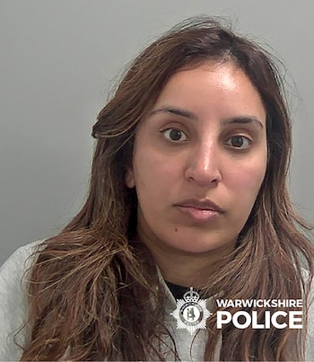 Primer plano de mujer con cabello castaño y largo, ojos abiertos y boca cerrada, vestida con sudadera gris. El logo de Warwickshire Police está visible