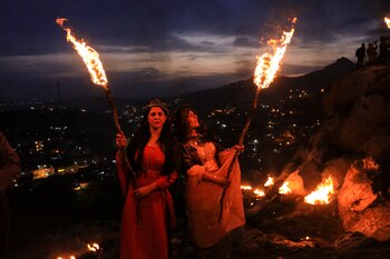 Iraqi Kurdish people carry fire torches, as they celebrate Nowruz Day, a festival marking the first day of spring and Persian New Year, in the town of Akra near Duhok, in Iraqi Kurdistan, Iraq March 20, 2022. REUTERS/Ari Jalal