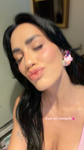 Retrato de una mujer de cabello negro con los ojos cerrados que hace un gesto de beso, con la frase en pantalla "Casi mi cumple"