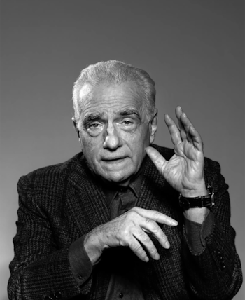 Primer plano en blanco y negro de Martin Scorsese, un hombre con cabello gris y chaqueta oscura, gesticulando con la mano derecha que tiene un reloj