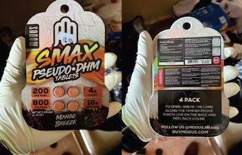 Manos con guantes blancos sostienen la parte frontal y posterior del paquete de tabletas de la marca Modus Smax Pseudo-DHM