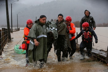 Personal de carabineros y emergencias evacuan a personas que se mantenían aisladas debido al desborde del río Pichilo, producto de las fuertes lluvias, en la región del Bio Bío (Chile) (EFE/ Ignacio Vásquez/Archivo)