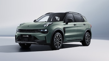Un SUV color verde claro con techo y rines negros, faros encendidos y el nombre Lynk&Co 01 visible en la parrilla frontal