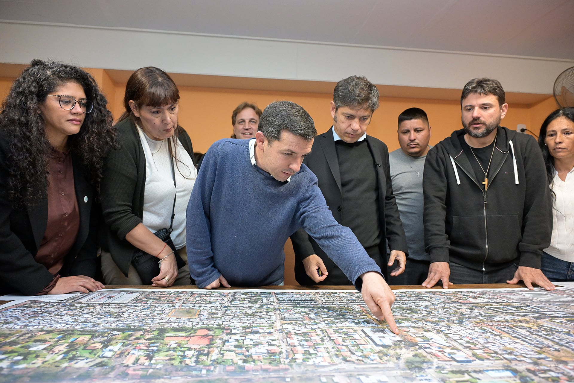 El gobernador Axel Kicillof, el intendente Ramón Lanús y el dirigente Juan Grabois observan un mapa urbano durante una reunión en San Isidro.