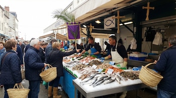 Un puesto de mercado exterior con pescado y marisco fresco sobre hielo es atendido por vendedores. Numerosos compradores con cestas de mimbre seleccionan productos.