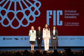 Cuatro mujeres de pie en un escenario. Al fondo, una pantalla roja con el logo del Festival Internacional Cervantino, texto y logos de auspiciantes