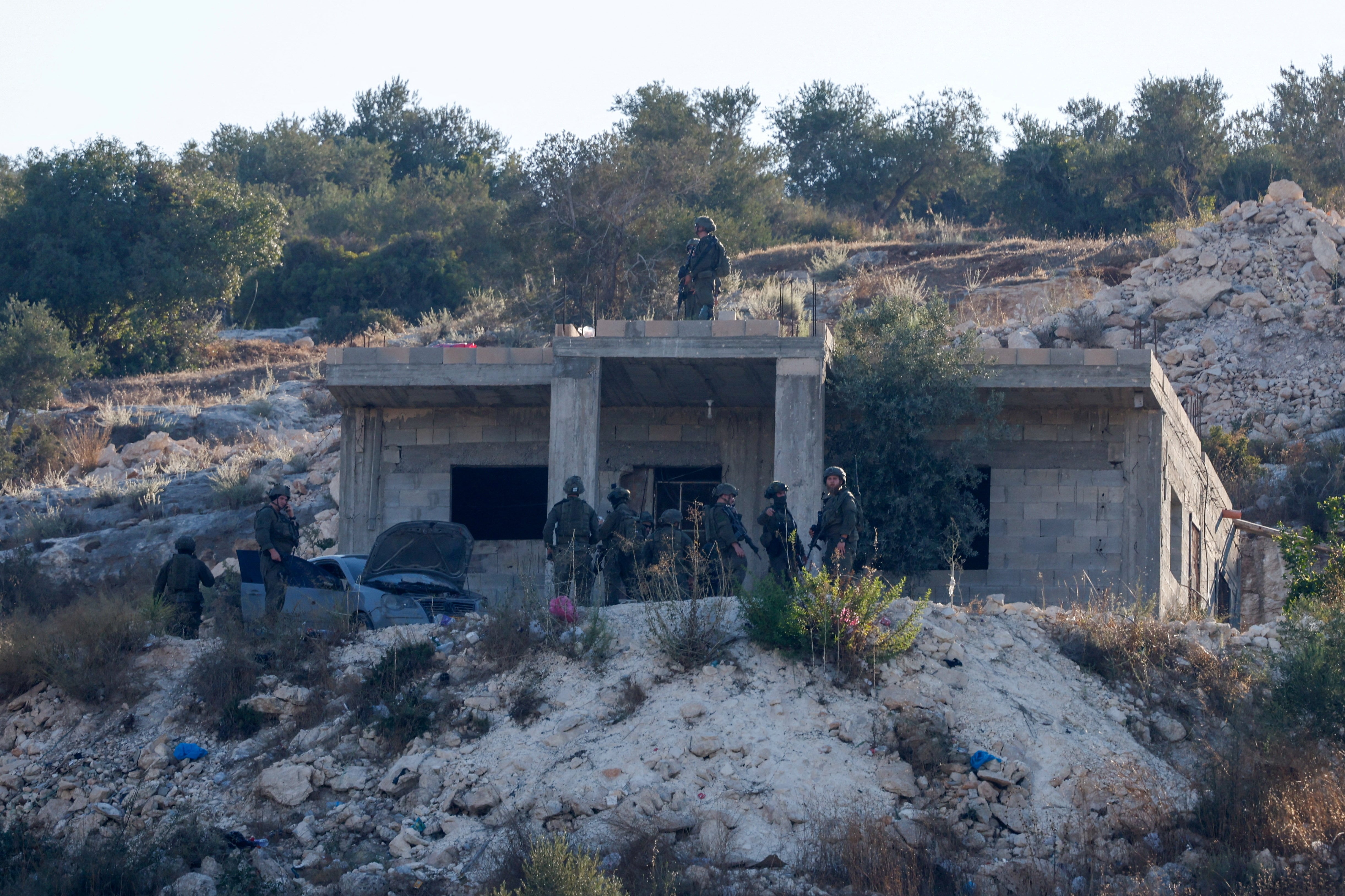 Fuerzas militares israelíes permanecen junto a un edificio, tras un ataque aéreo militar israelí, en Jenin, en la Cisjordania ocupada por Israel, el 28 de agosto de 2026. REUTERS/Mohammed Torokman