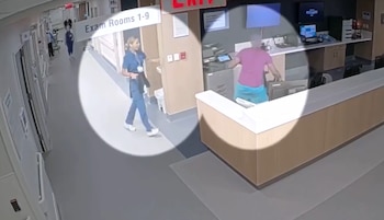 Captura de cámara de seguridad de un hospital con una enfermera en uniforme azul y un hombre detrás de un mostrador resaltados en un círculo