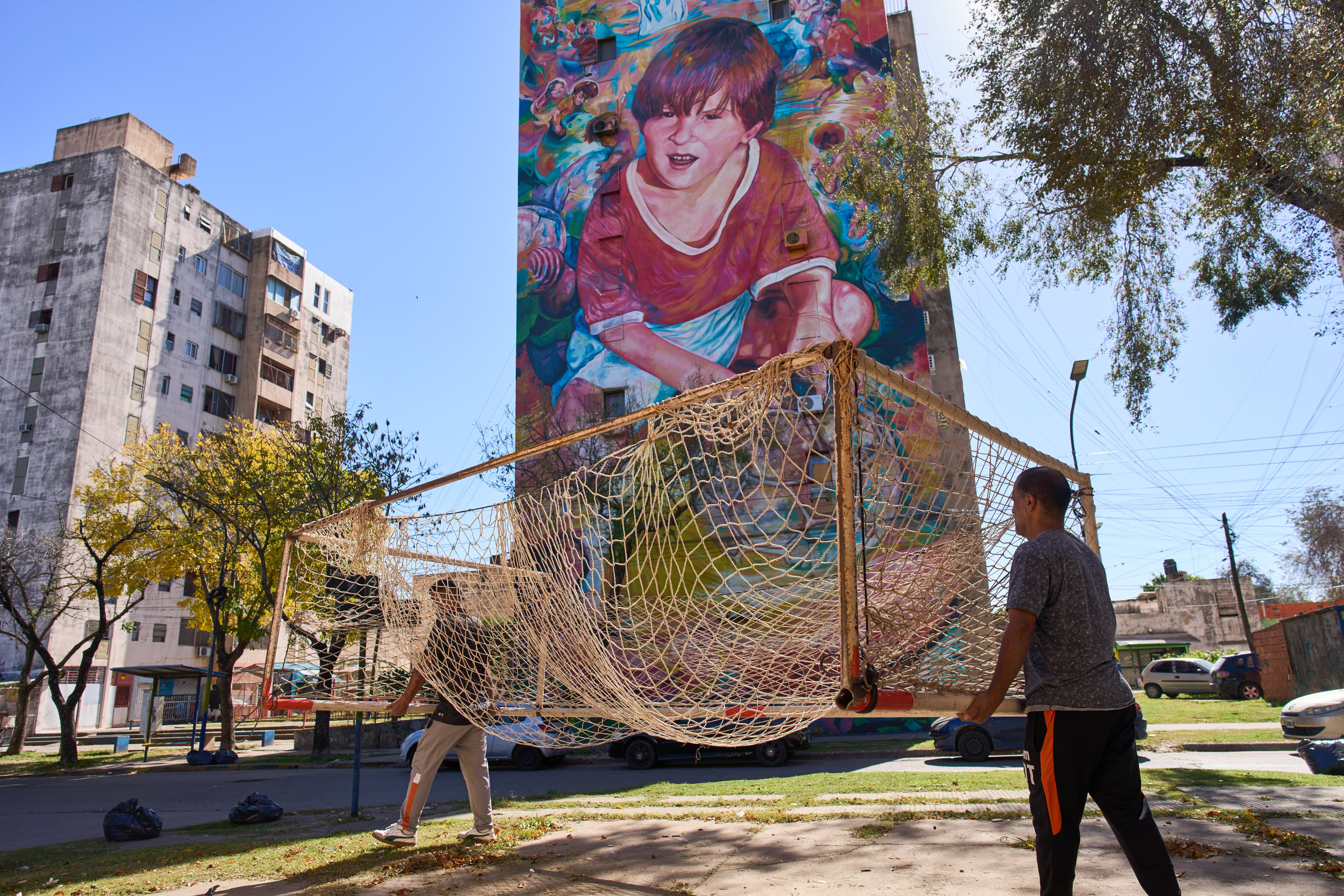 Empleados del club de fútbol Grandoli cargan un arco en la cancha para un partido de fútbol infantil en Rosario, Argentina, el sábado 2 de mayo de 2026. (AP Foto/Rodrigo Abd)