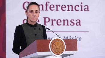 Mujer con chaqueta oscura frente a un podio. Micrófonos y Escudo Nacional de México visibles. Fondo blanco con texto 'Conferencia de Prensa'.