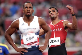 Tokyo 2020 Olympics - Athletics - Men's 100m - Round 1 - OLS - Olympic Stadium, Tokyo, Japan - July 31, 2021. Kojo Musah of Denmark and Chijindu Ujah of Britain react after competing in Heat 7 REUTERS/Hannah Mckay