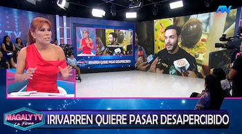Magaly Medina, com cabelos acobreados e vestido vermelho, posa no show. Em uma tela você pode ver Mario Irivarren, barbudo, sendo entrevistado.