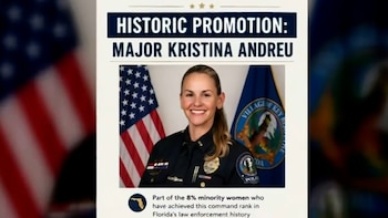 Retrato de la Mayor Kristina Andreu con uniforme de policía, sonriendo, flanqueada por la bandera de Estados Unidos y la bandera de la policía de Key Biscayne