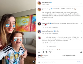 Una mujer y un niño sonríen con la bandera argentina pintada en sus mejillas, el niño usa una camiseta de fútbol, detrás hay una pintura abstracta