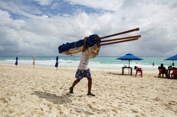 A hotel employee removes beach