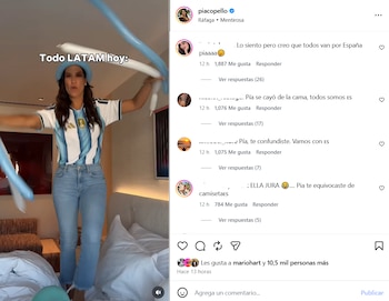 Mujer de pie sobre una cama, viste camiseta de fútbol celeste y blanca con jeans, sujeta globos alargados celestes y blancos en un dormitorio con una interfaz de red social