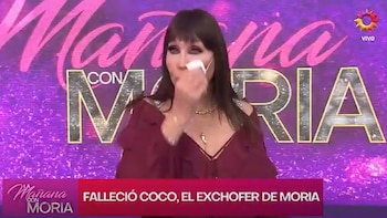 Moria Casán sostiene un pañuelo cerca de su rostro ante una pantalla morada con el nombre del ciclo y un rótulo informativo inferior