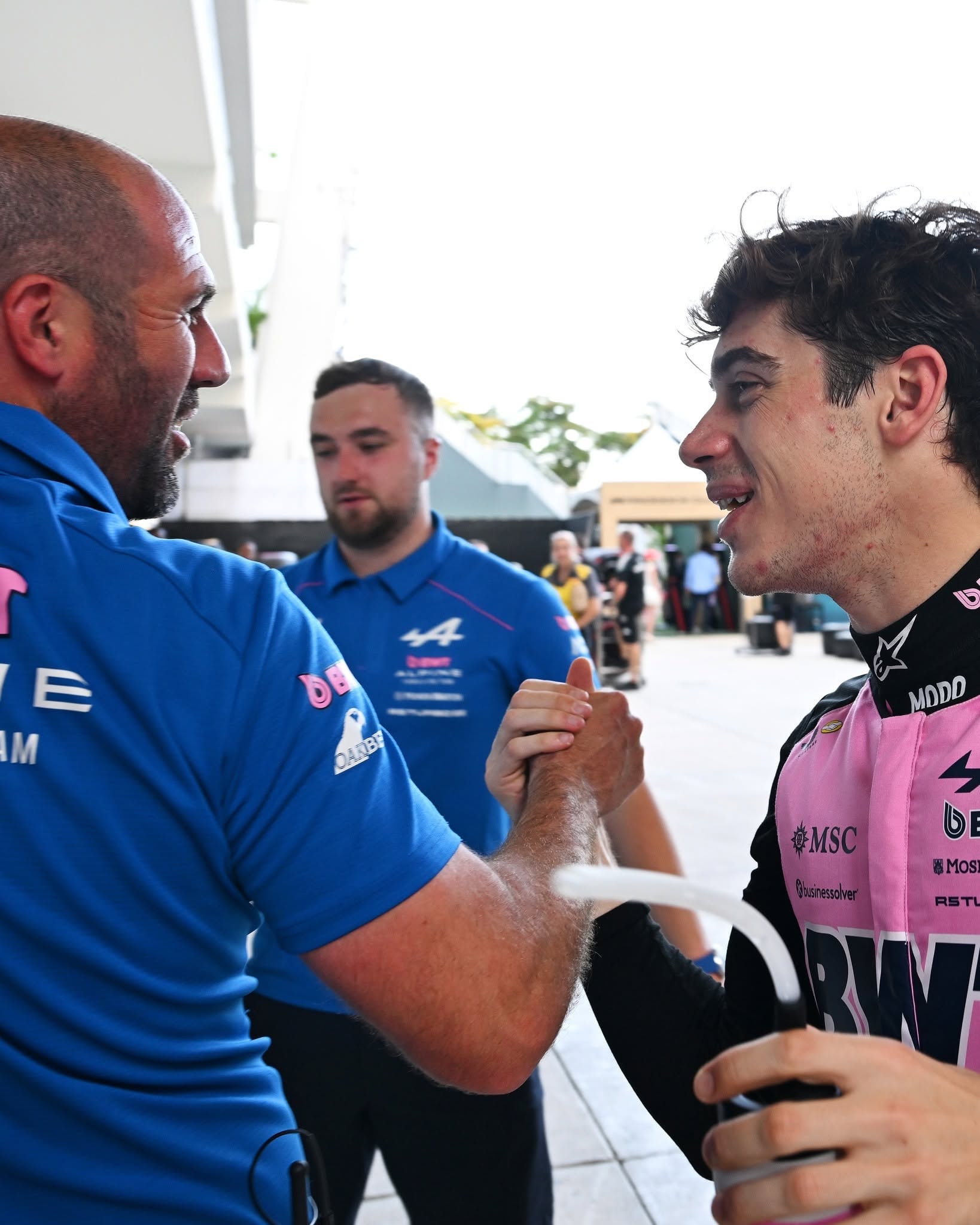 El piloto argentino Franco Colapinto celebra su clasificación para el Gran Premio de Miami de Fórmula 1 con un miembro de su equipo.