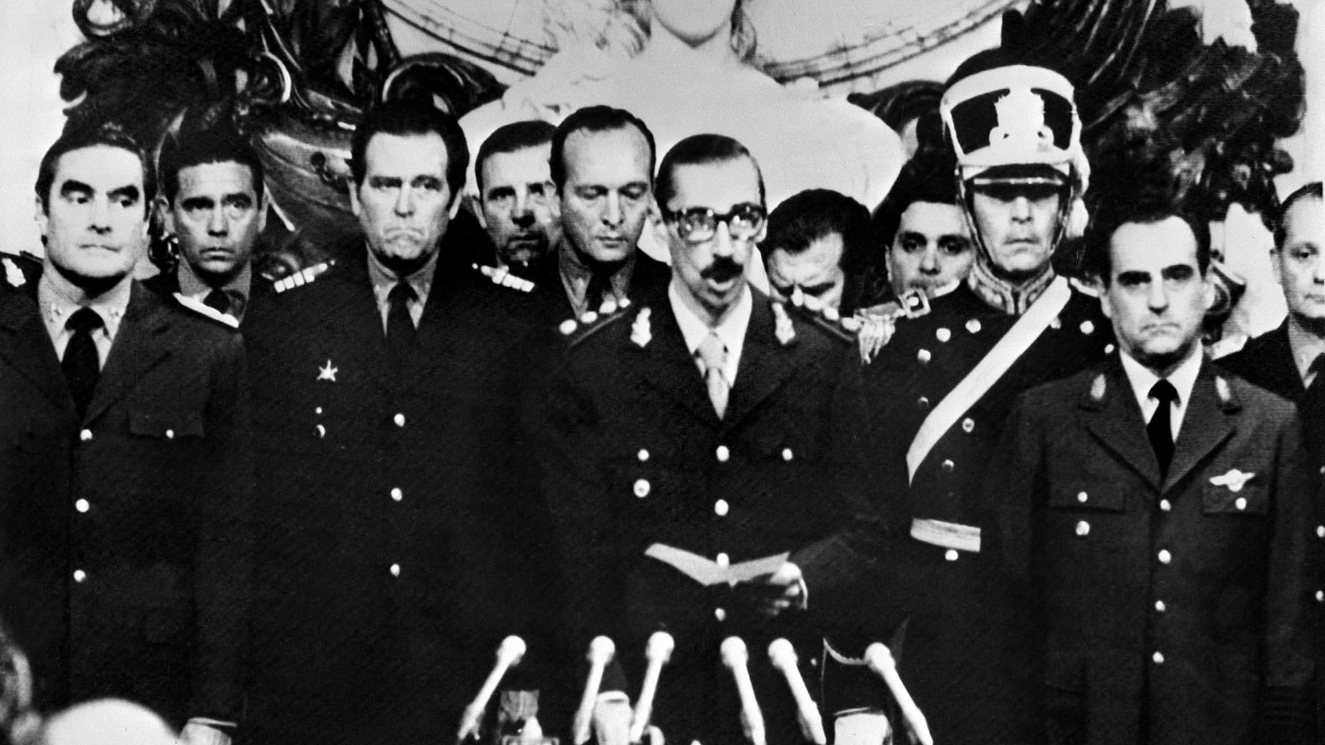 El 29 de marzo de 1976 el dictador Jorge Rafael Videla tomaba juramento como presidente de la Argentina, luego del golpe de estado militar del 24 de marzo de 1976. A la izquierda esta el almirante Eduardo Emilio Massera y a la derecha el brigadier Orlando Ramon Agosti (Photo by AFP)