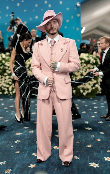 Traje rosa claro de corte amplio con chaleco, camisa, corbata y sombrero de ala ancha a juego, anillos y broche en la solapa para una gala (REUTERS/Mario Anzuoni)