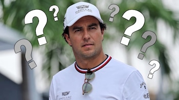 Sergio Pérez con gorra y camiseta blancas de Cadillac Formula 1 Team y varios signos de interrogación dibujados alrededor de su cabeza.