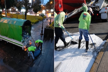 Trabajadores con ropa de protección cargan bolsas en un camión y cepillan espuma sobre el asfalto junto a un vehículo.