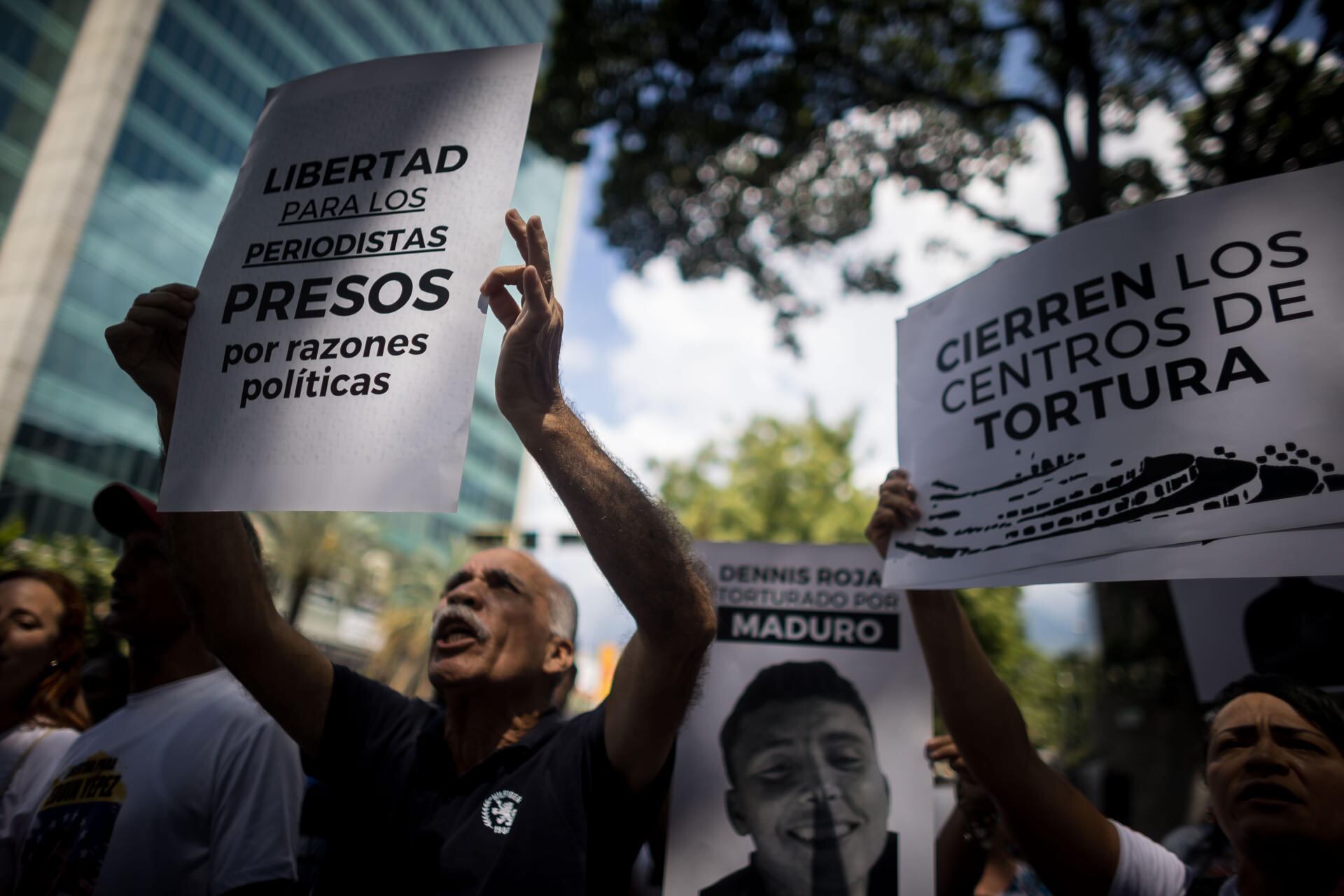 Fotografía de archivo de personas que sostienen carteles con imágenes de presos políticos durante una manifestación frente a la sede del Ministerio de Servicio Penitenciario, en Caracas (EFE/ Miguel Gutierrez)