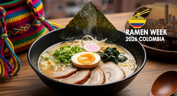 Primer plano de un tazón de ramen humeante con fideos, cerdo, huevo, nori y cebolla, junto a una mochila colombiana. Logo del Ramen Week 2026 Colombia con paisaje urbano.
