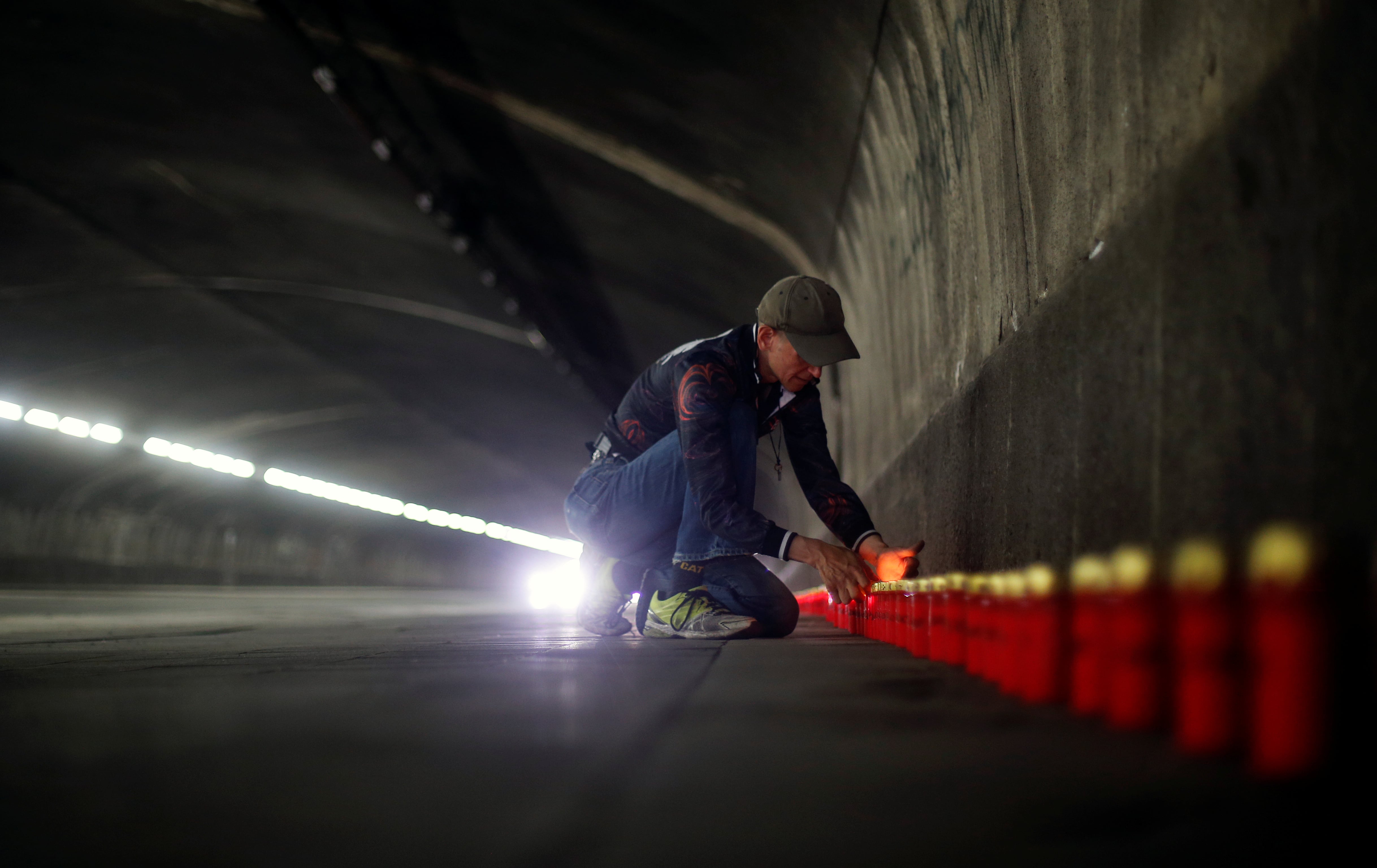 Un hombre enciende una vela en la conmemoración del décimo aniversario de la Tragedia del Love Parade. El túnel fue el terminó siendo una trampa mortal (REUTERS)