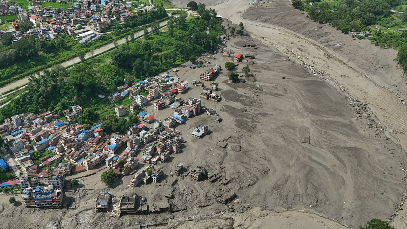 Viviendas dañadas cerca de la orilla, llena de escombros, del río Trishuli, tras las inundaciones repentinas, en el distrito de Nuwakot, Nepal, el 26 de agosto de 2026 (AP/Niranjan Shrestha)