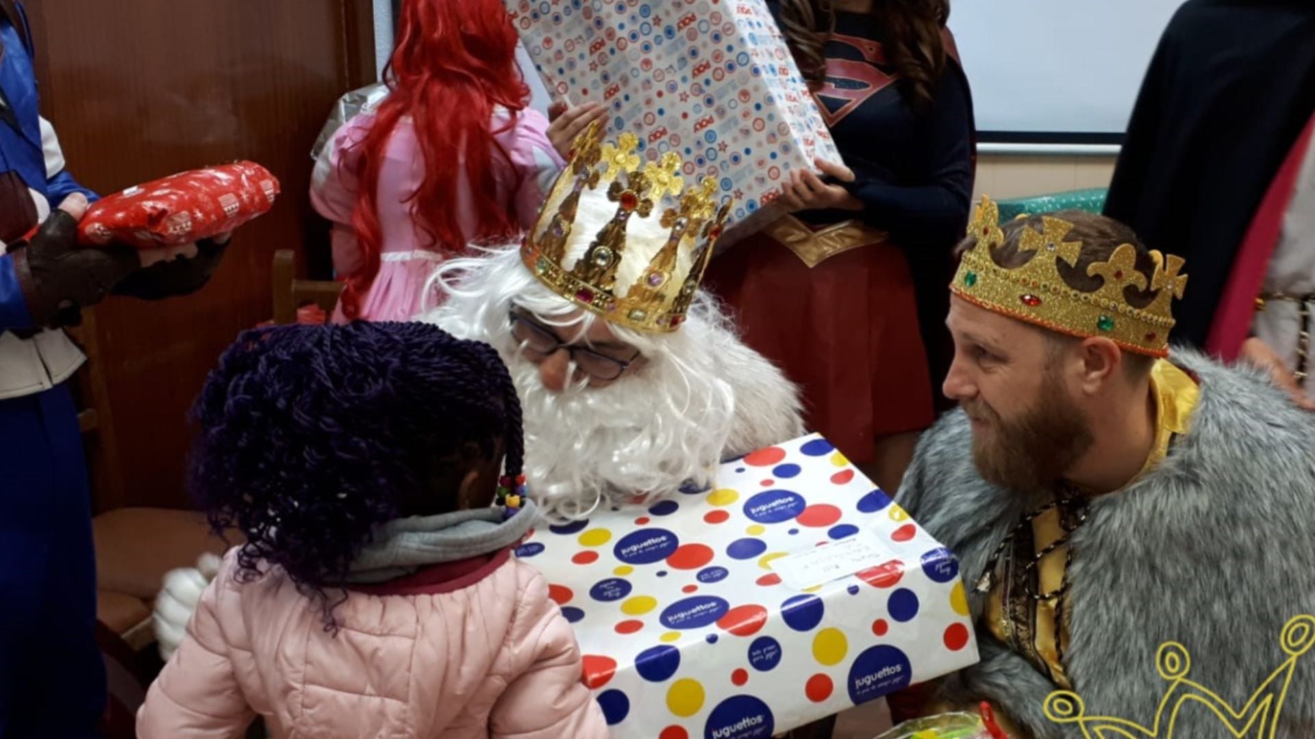 Una niña recibiendo un regalo de los Reyes Magos (Reyes Magos de Verdad)