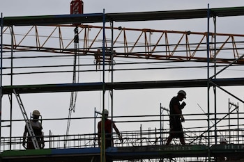 Constructores trabajando sobre andamios en