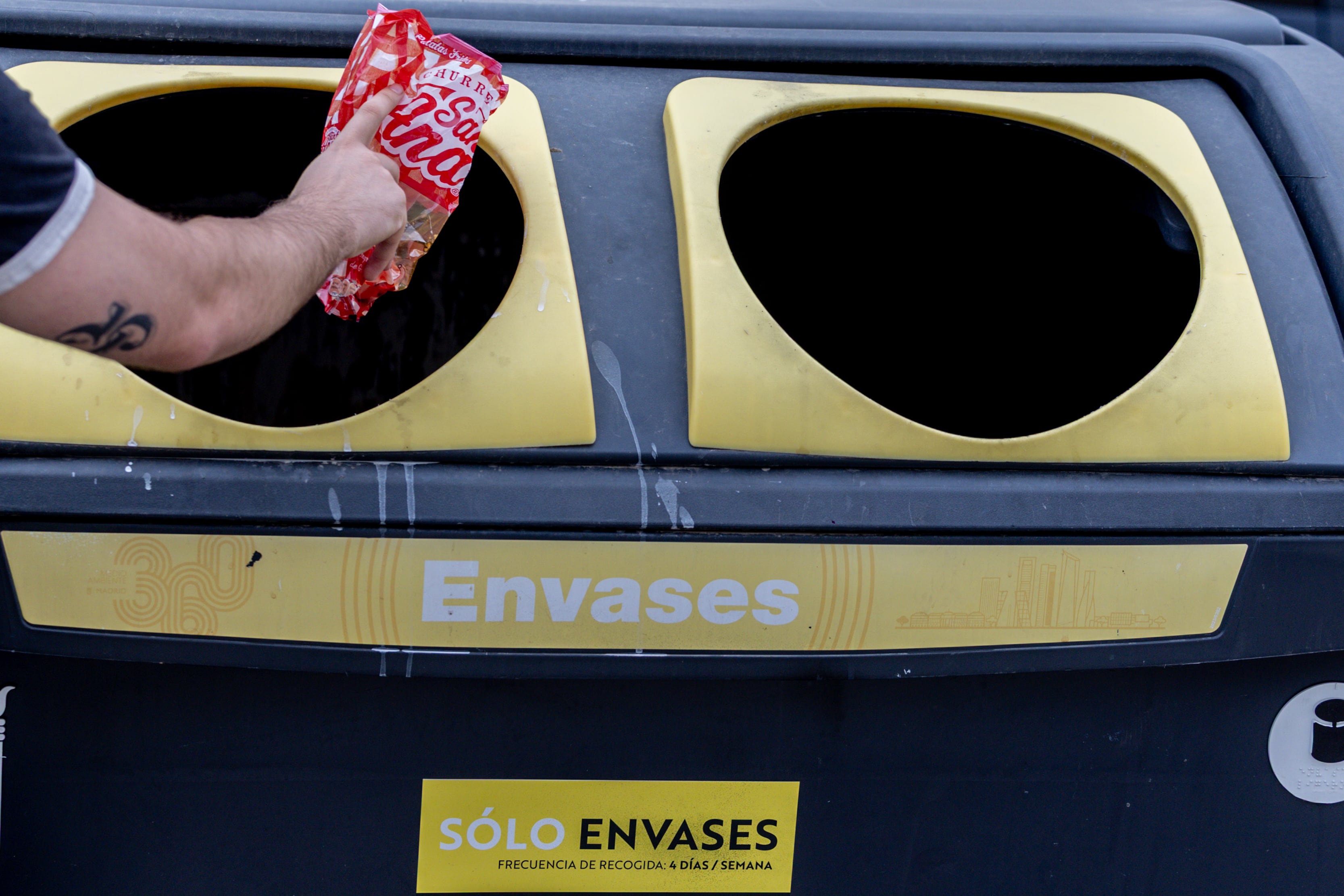 Una persona tira una bolsa de plástico en un contenedor de basura de envases en Madrid (Ricardo Rubio / Europa Press)