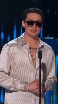 El cantante mexicano Peso Pluma habla ante un micrófono en un escenario durante una ceremonia de premios. (Premios Billboard Latinoamérica)