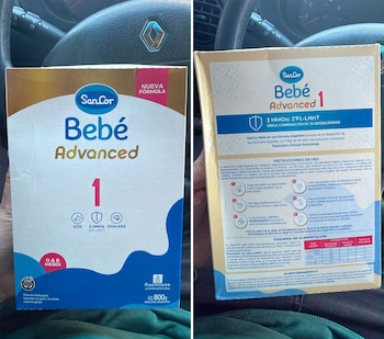 Frente y dorso de una caja de cartón de fórmula infantil SanCor Bebé Advanced 1 sostenida frente al volante de un automóvil