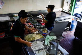 Las mujeres preparan Pupusas (comida tradicional salvadoreña) para llevar en el restaurante Pupuseria Lilian después de que el gobierno de el Salvador anunciara el cierre de restaurantes y medidas para aliviar el efecto de la enfermedad del coronavirus (COVID-19), en Antiguo Cuscatlán, el Salvador, 18 de marzo de 2020. REUTERS/José cabezas