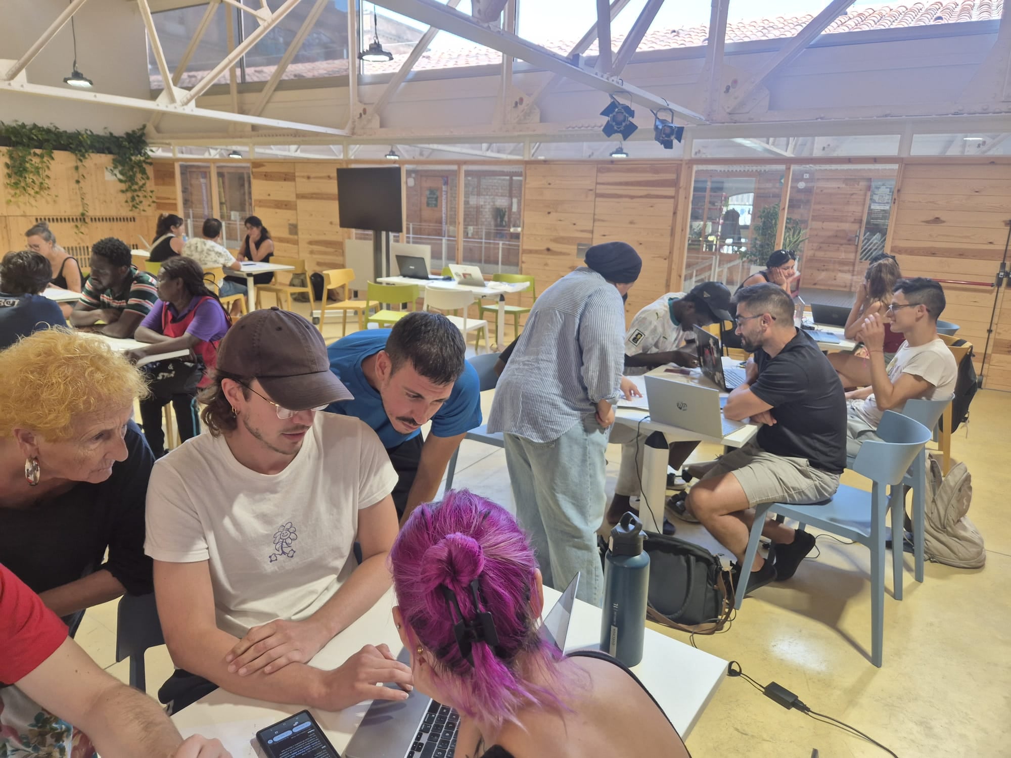 Varias personas migrantes en el espacio Bloc4BCN este verano para tratar de solucionar dudas sobre la regularización. (Cedida a Infobae)