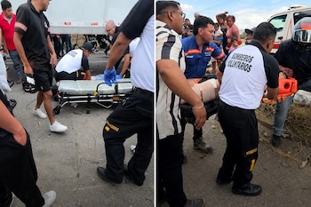Bomberos voluntarios con uniforme negro y blanco preparan una camilla y trasladan a una persona lesionada.