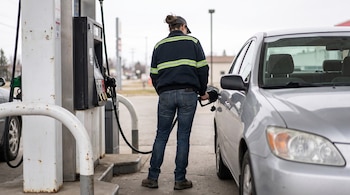 Una trabajadora de una gasolinera reposta un coche (Imagen ilustrativa Infobae)