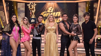 Seis personas posan en un escenario de televisión con un trofeo dorado y el logotipo del programa El Gran Show al fondo.