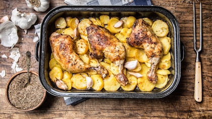 Muslos de pollo al horno con patatas panaderas, una receta fácil para conquistar a todo el que se siente a la mesa
