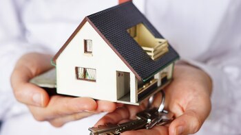 A closeup shot of a person thinking of buying or selling a house